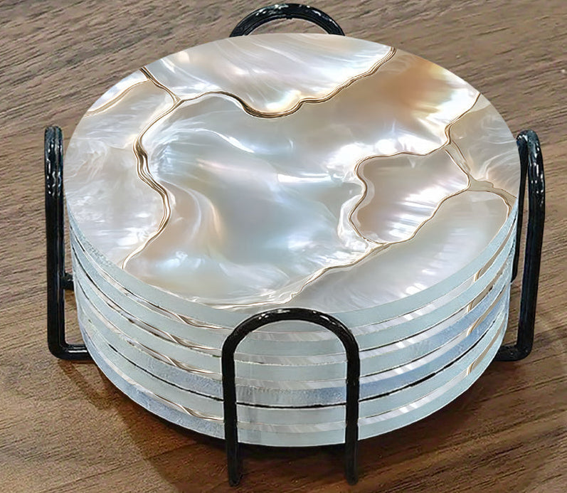 Set of six round white coasters with a black metal holder on a wooden surface.