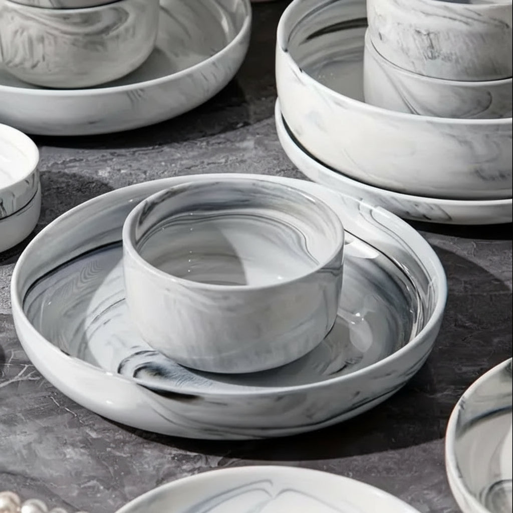 Set of marble-patterned ceramic dishes on a dark surface