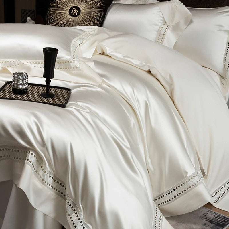 White bedspread with decorative stitching on a bed, featuring a brand logo.