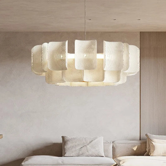 Modern chandelier hanging above a sofa in a living room setting.